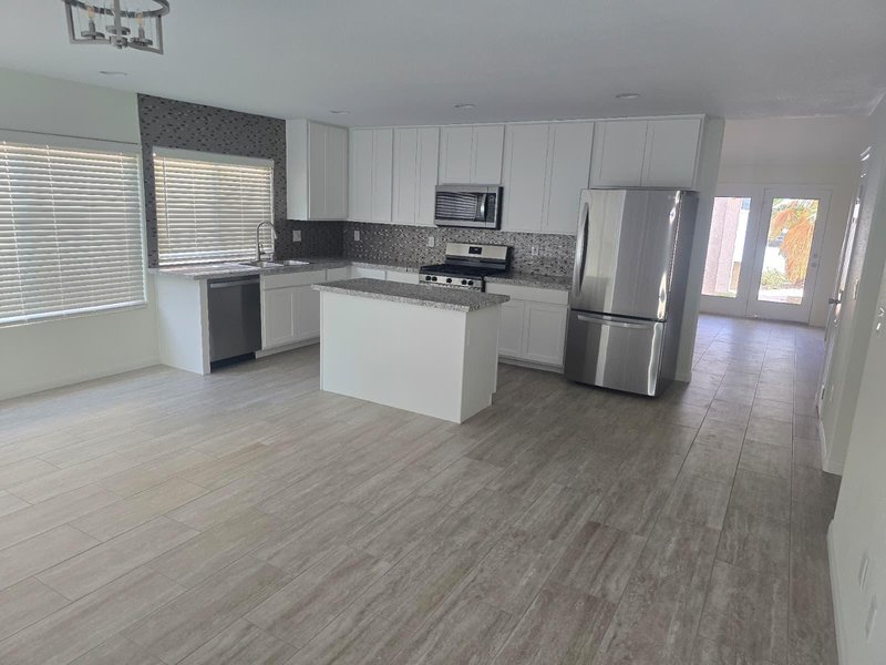 Cocina blanca con backsplash de mosaico y piso de cerámica