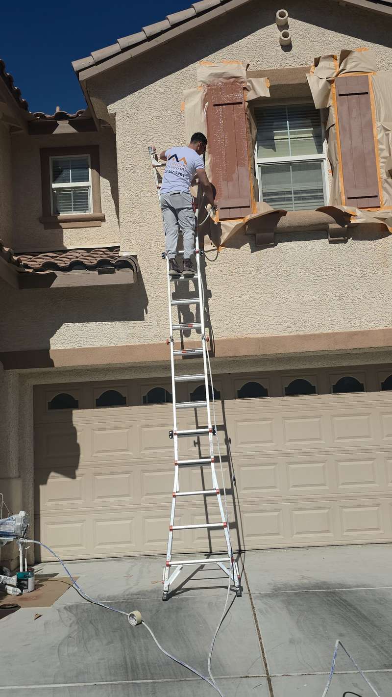 Pintor de Ecofloor aplicando pintura a los shutters de una casa en Las Vegas
