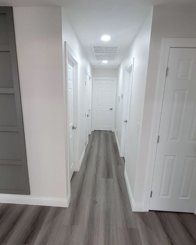 Hallway with gray SPC flooring and white baseboards